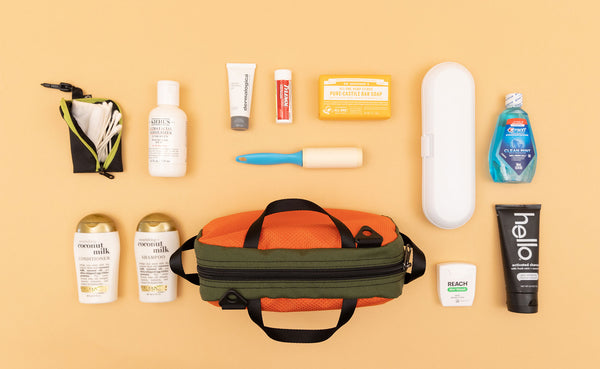 a Texturized Orange Grab Bag with various travel toiletry items next to it.
